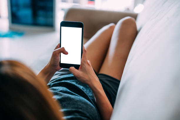istock An Asian woman lying down on sofa and using mobile smart phone at living room 1372002742