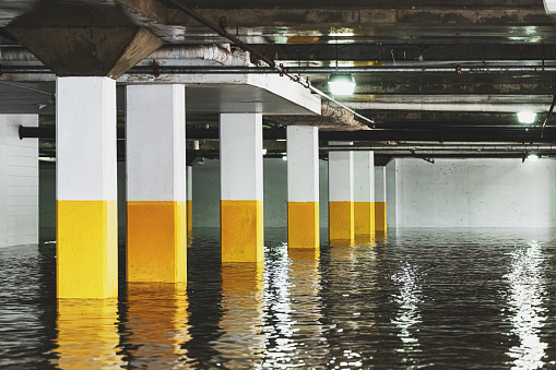 A river has overflowed its banks, flooding a parking garage.