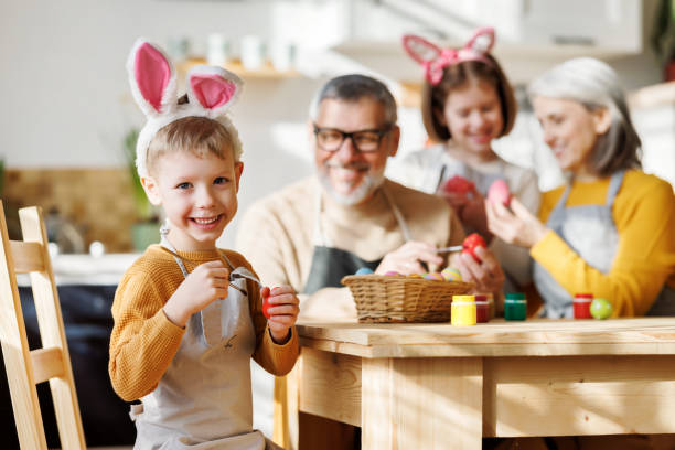 istock Happy little children creating beautiful painted eggs for Easter with loving senior grandparents 1372006489