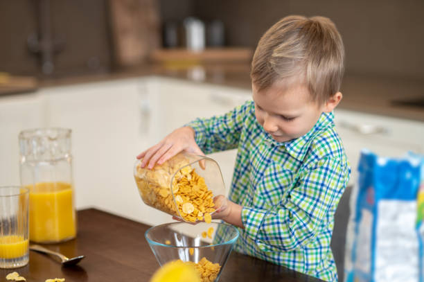 istock Focused hungry kid preparing an oatmeal dish for breakfast 1372007717