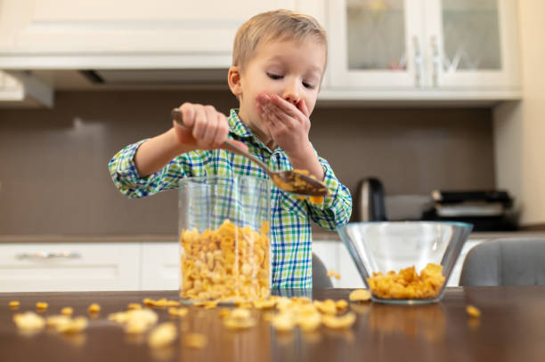 istock Scared kid adding oatmeal ingredients to a glass bowl 1372007735