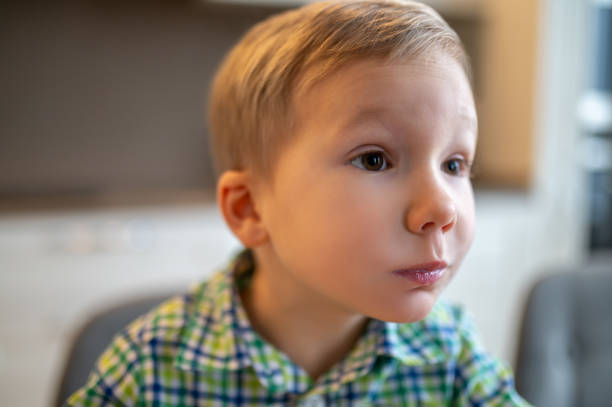 istock Surprised boy seated with his mouth full looking at something 1372007742