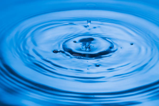 Bluewater bubbles on the surface ripples. Defocus blurred transparent white-black colored clear calm water surface texture with splash and bubbles. Water waves with shining pattern texture background.
