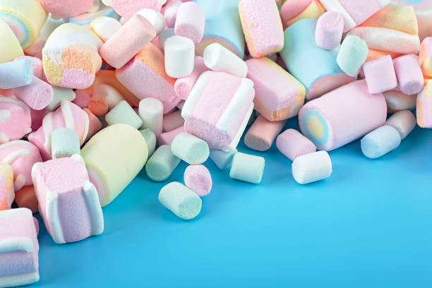 istock Colorful marshmallows on a blue background. Delicious dessert. Fluffy marshmallows. 1372011378