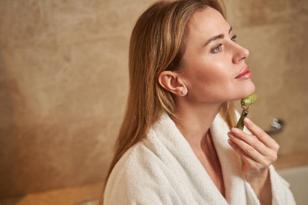 istock Self-loving woman massaging her face with a special roller 1372012879