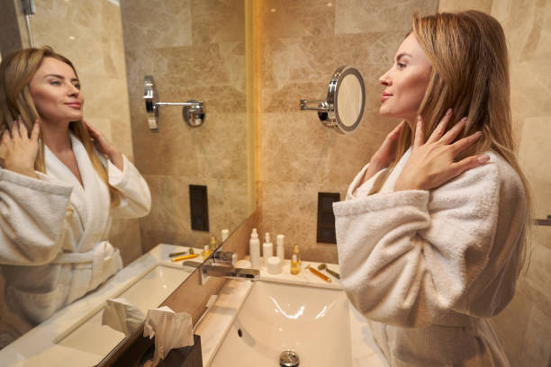 istock Contented lady admiring herself in bathroom mirror 1372012913