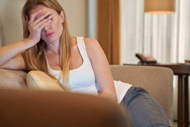 istock Stressed female worker on sofa covering her eyes 1372012957