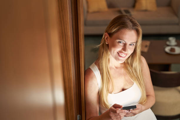 istock Joyful woman looking up from bookreader into camera and smiling 1372012990