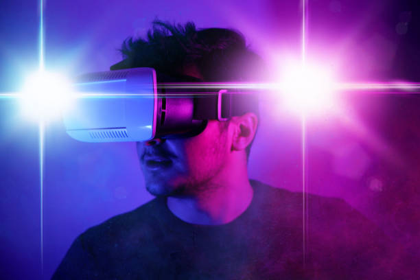 istock Young man discovering metaverse by using VR glasses under neon lights 1372013720
