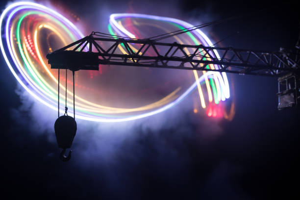 istock Abstract Industrial background with construction crane silhouette over amazing night sky with fog and backlight. Tower crane against the foggy sky at night. 1372014173