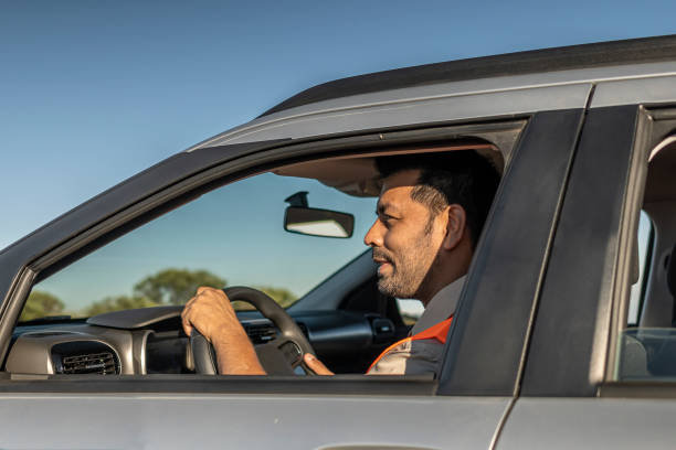 istock Electrical engineer with protective equipment in a moving car on the way to wind power plant. 1372015252