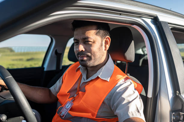 istock Electrical engineer with protective equipment in a moving car on the way to wind power plant. 1372015309
