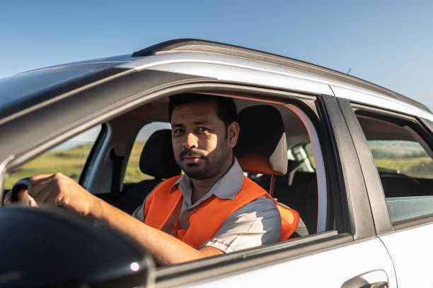 istock Electrical engineer with protective equipment in a moving car on the way to wind power plant. 1372015324