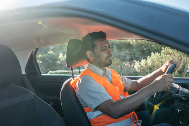 istock Electrical engineer with protective equipment in a moving car on the way to wind power plant. 1372015396