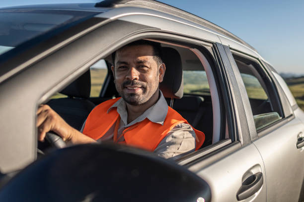 istock Electrical engineer with protective equipment in a moving car on the way to wind power plant. 1372015577