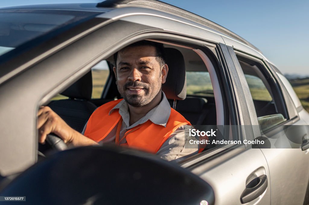 Electrical engineer with protective equipment in a moving car on the way to wind power plant. Electrical engineer with protective equipment in a moving car on the way to wind power plant. Bom Jardim da Serra wind farm / Santa Catarina Technician Stock Photo