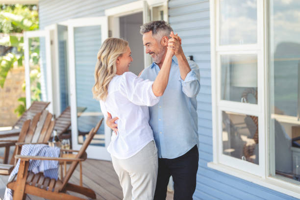 pareja madura bailando en una casa o hotel o villa de vacaciones. - mature adult couple caucasian outdoors fotografías e imágenes de stock