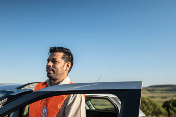 istock Electrical engineer with protective equipment getting out of an electric car in a wind farm park 1372016432