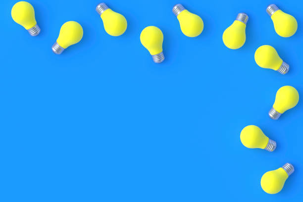 istock Scattered yellow light bulbs on blue background. Top view. Copy space. 3d render 1372016797