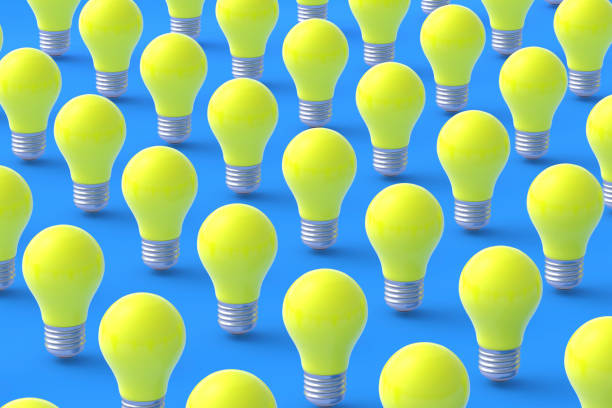 istock Rows of many yellow light bulbs on blue background. 3d render 1372016810