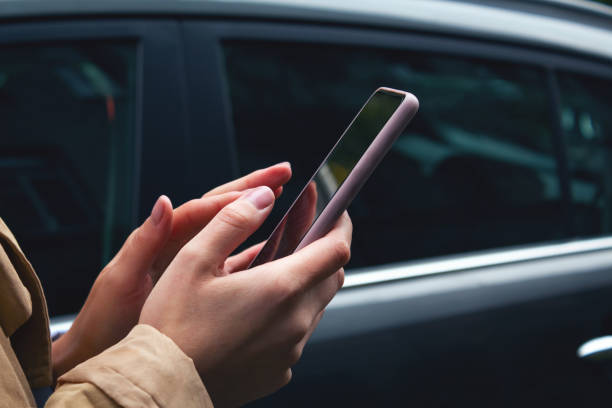 istock Woman holding mobile phone in hands. Carsharing 1372017993