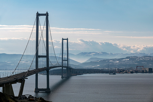 Osmangazi Bridge (Izmit Bay Bridge) in Kocaeli, Turkey. Longest bridge in Turkey and the fourth-longest suspension bridge in the world by the length of its central span. The shipyard area is seen in the background.