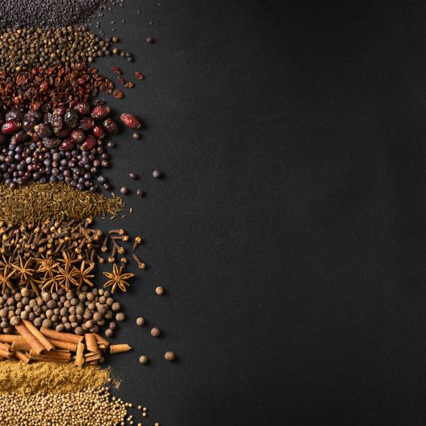 istock Spices and herbs on background of black table with empty space. 1372020433
