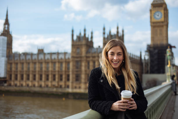 istock Young woman drinking coffee in a disposable cup on Westminster Bridge 1372020528