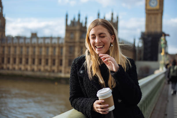 istock Young woman drinking coffee in a disposable cup on Westminster Bridge 1372020560