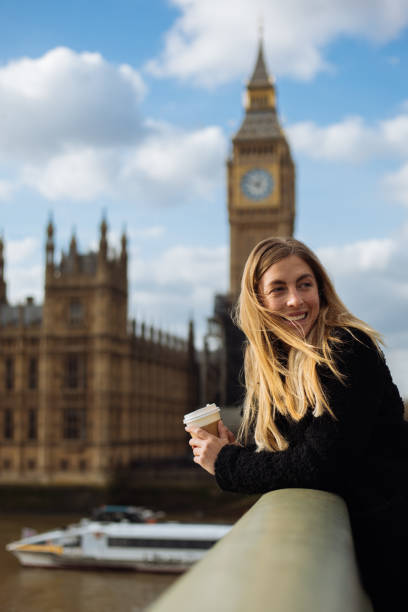 istock Young woman drinking coffee in a disposable cup on Westminster Bridge 1372020586