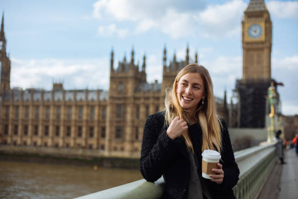 istock Young woman drinking coffee in a disposable cup on Westminster Bridge 1372020602