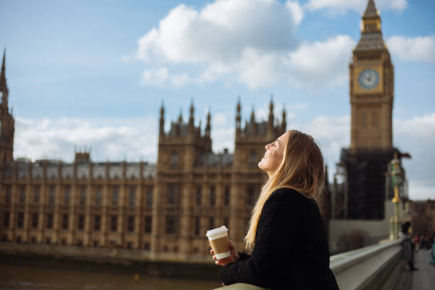 istock Young woman drinking coffee in a disposable cup on Westminster Bridge 1372020609