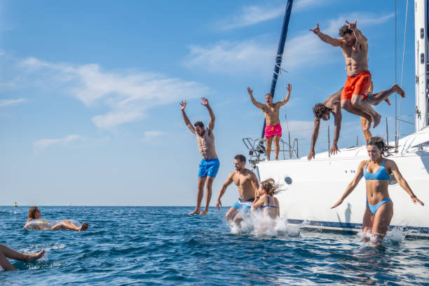 istock Group of young people jumping down from yacht into water 1372026072