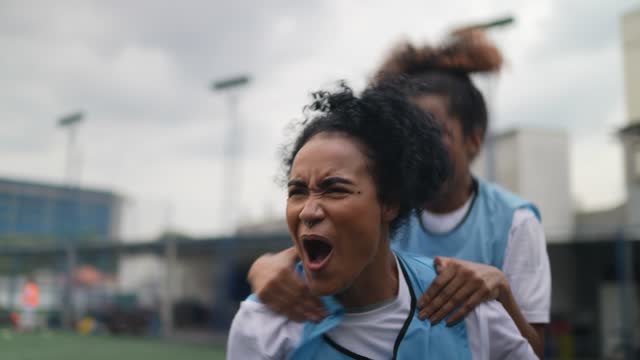 Female soccer playes celebrating celebrating a goal