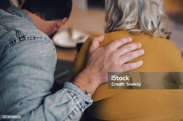 Son Hugging His Mother While Sitting On The Couch Stock Photo - Download Image Now - Shoulder, Hand, Arm