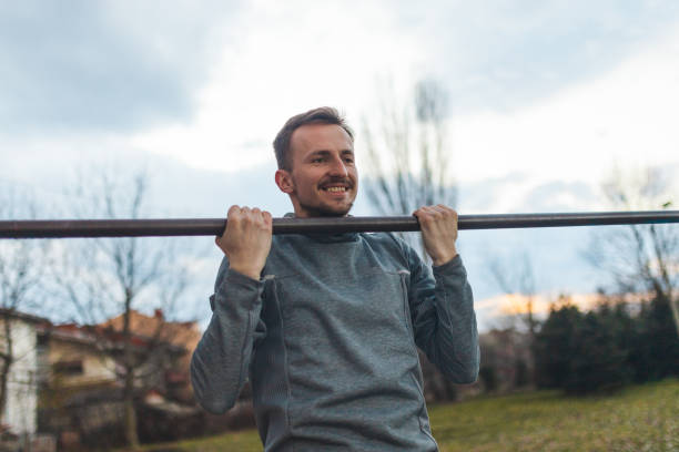 istock Young male athlete pulling himself on a gymnastics bar outdoors 1372029185