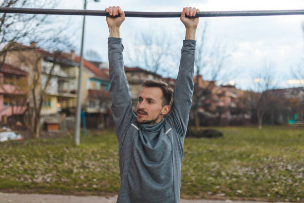 istock Young male athlete pulling himself on a gymnastics bar outdoors 1372029189