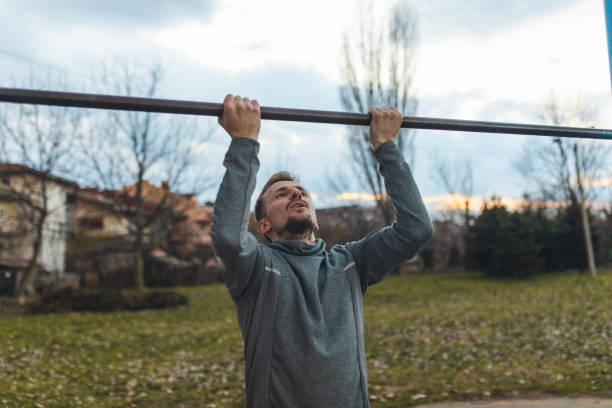 istock Young male athlete pulling himself on a gymnastics bar outdoors 1372029192