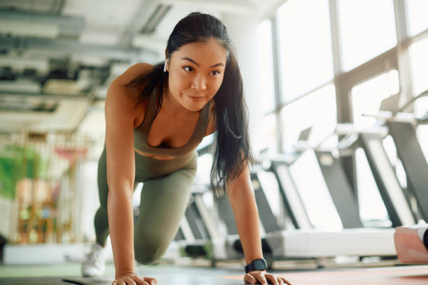 istock Young Asian sportswoman doing running plank exercise while working out in a gym. 1372029288
