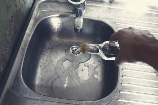 a man pours alcohol into the sink. sober life. close-up. background. - action alcohol alcoholism bar imagens e fotografias de stock