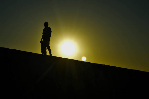 istock Silhouette of man walking at sunset 1372033398
