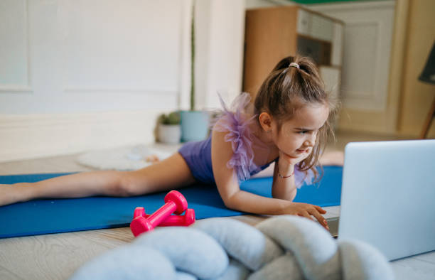 istock Pretty young ballerina practicing classic choreography during online class 1372034281