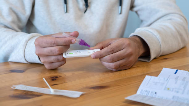 istock Close-up of man placing sample into a buffer dropper for seft detection of virus 1372034332