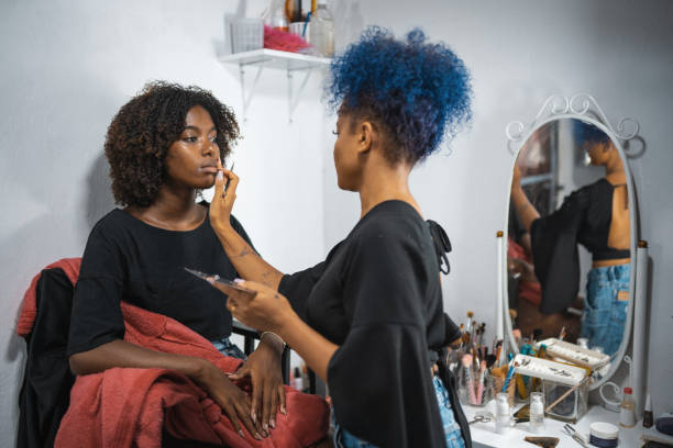 maquilladora aplicando maquillaje en los labios de la modelo - makeup artist fotografías e imágenes de stock