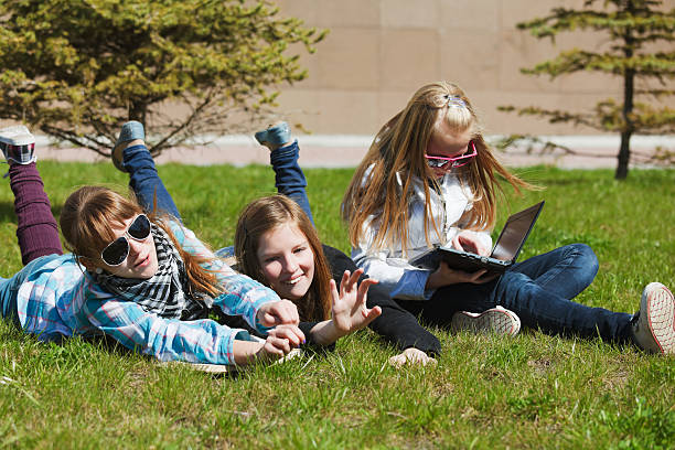 istock Schoolgirls lying on a grass 137203527