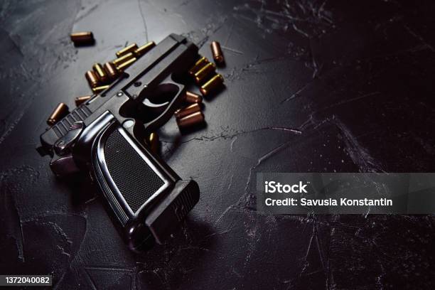 Pistol With Cartridges On Black Concrete Table Stock Photo - Download Image Now - Gun, Weapon, Handgun