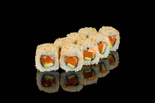 istock Roll with spicy salmon, avocado and sesame on black with reflection 1372041655