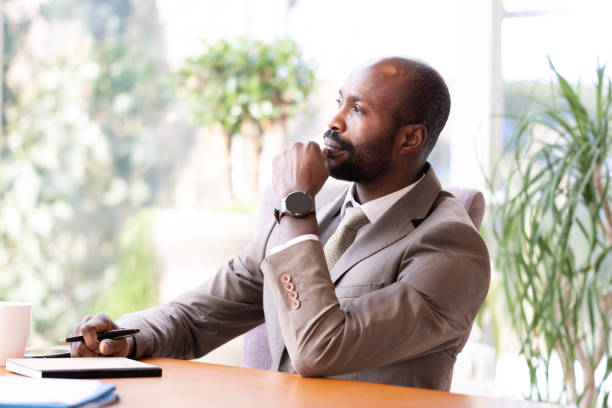 istock Black businessman at the table thinking 1372042972