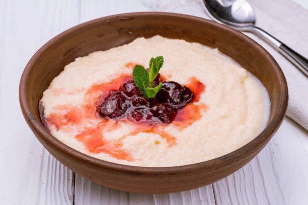 semolina in milk with jam on white wooden table