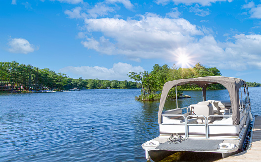 Jetty with Recreational boats at the Caloosahatchee River in Florida, USA. One boat moored at the jetty another boat on the river on the horizon.